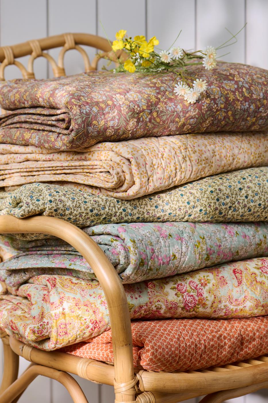 Vikta quilts från Ib Laursen i olika blommiga och mönstrade textilier i varma färger