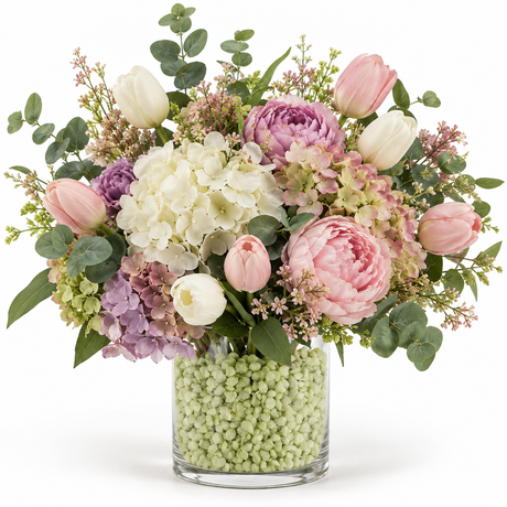 Glasvas med limegröna granulatstenar som vasfyllnad och en stor blombukett.
