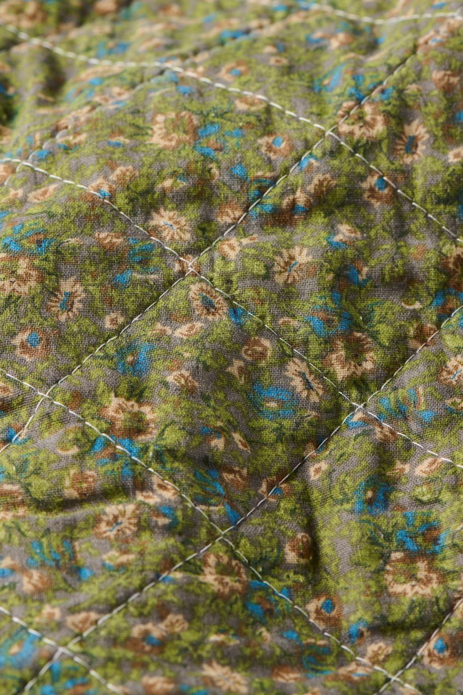 Närbild av småblommigt mönster på en quilt från Ib Laursen i dämpade färger