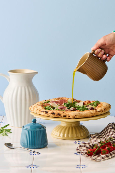 Vit mynta stengodskanna från Ib Laursen på ett sommardukat bord med paj, blommor och färgglatt porslin.