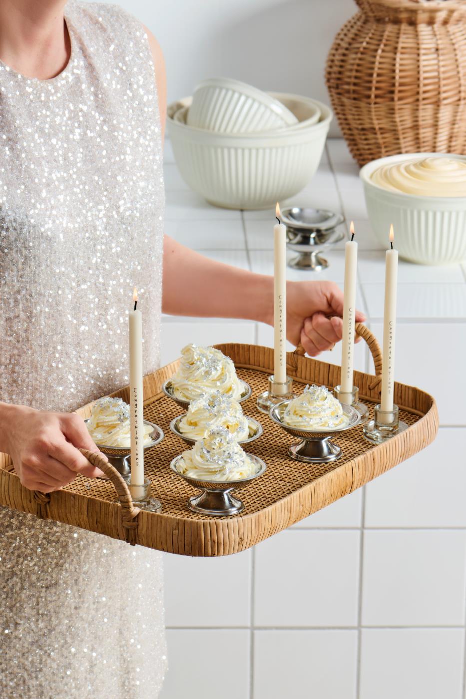 Liten stålskål med söta läckerheter på serveringsbricka med glas och annat serveringstillbehör
