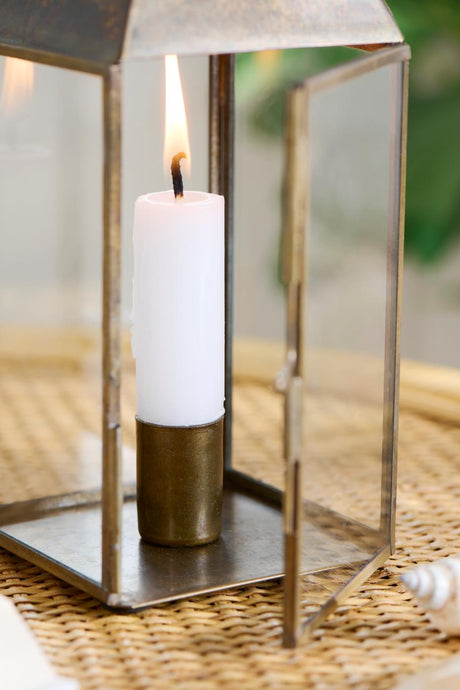 Antik guldfärgad magnetljusstake med vitt kronljus i glaslykta