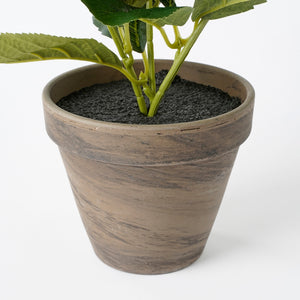Grå lerkrukke med en kunstig hortensia i