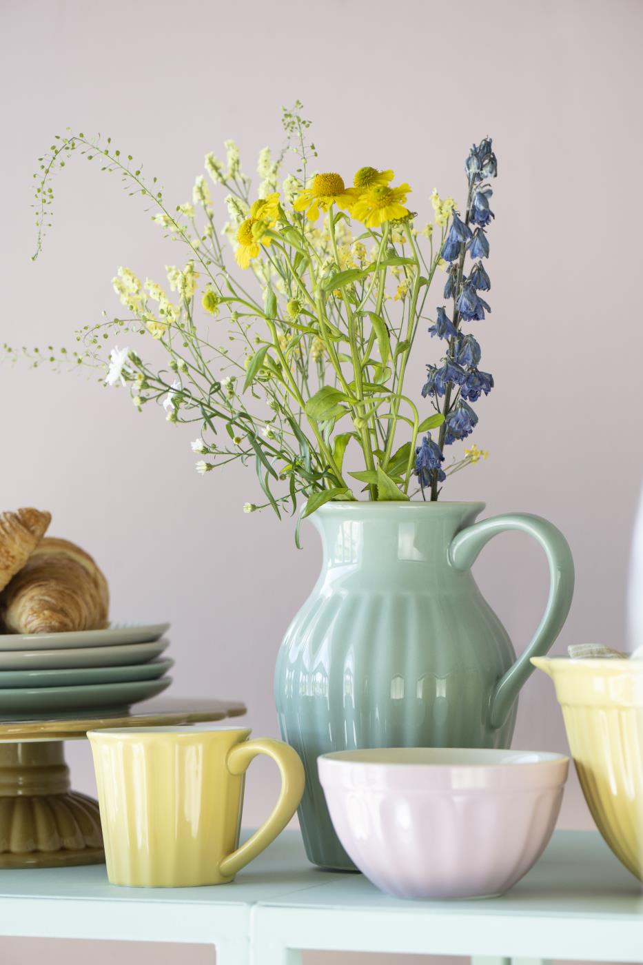 Mynte kande med blomsterbuket på bord med service